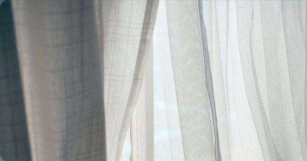 Sheer curtains moving at an open window